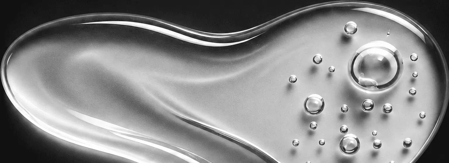 Close view of clear skincare gel with suspended droplets